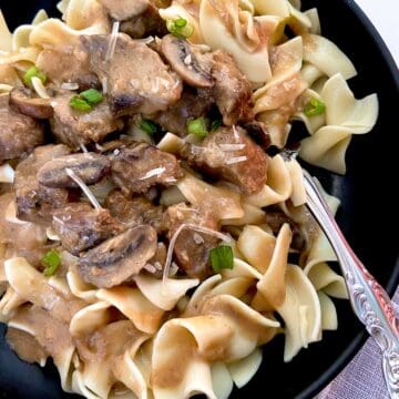 Beef stroganoff in black bowl.