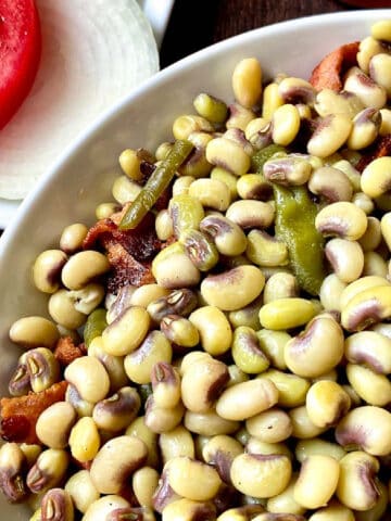 Purple hull peas in white bowl.