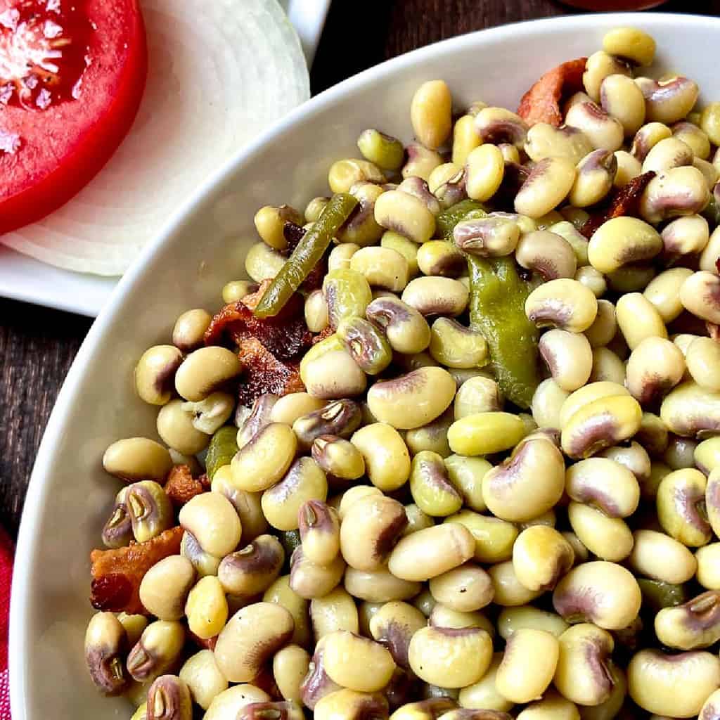 Purple hull peas in white bowl.