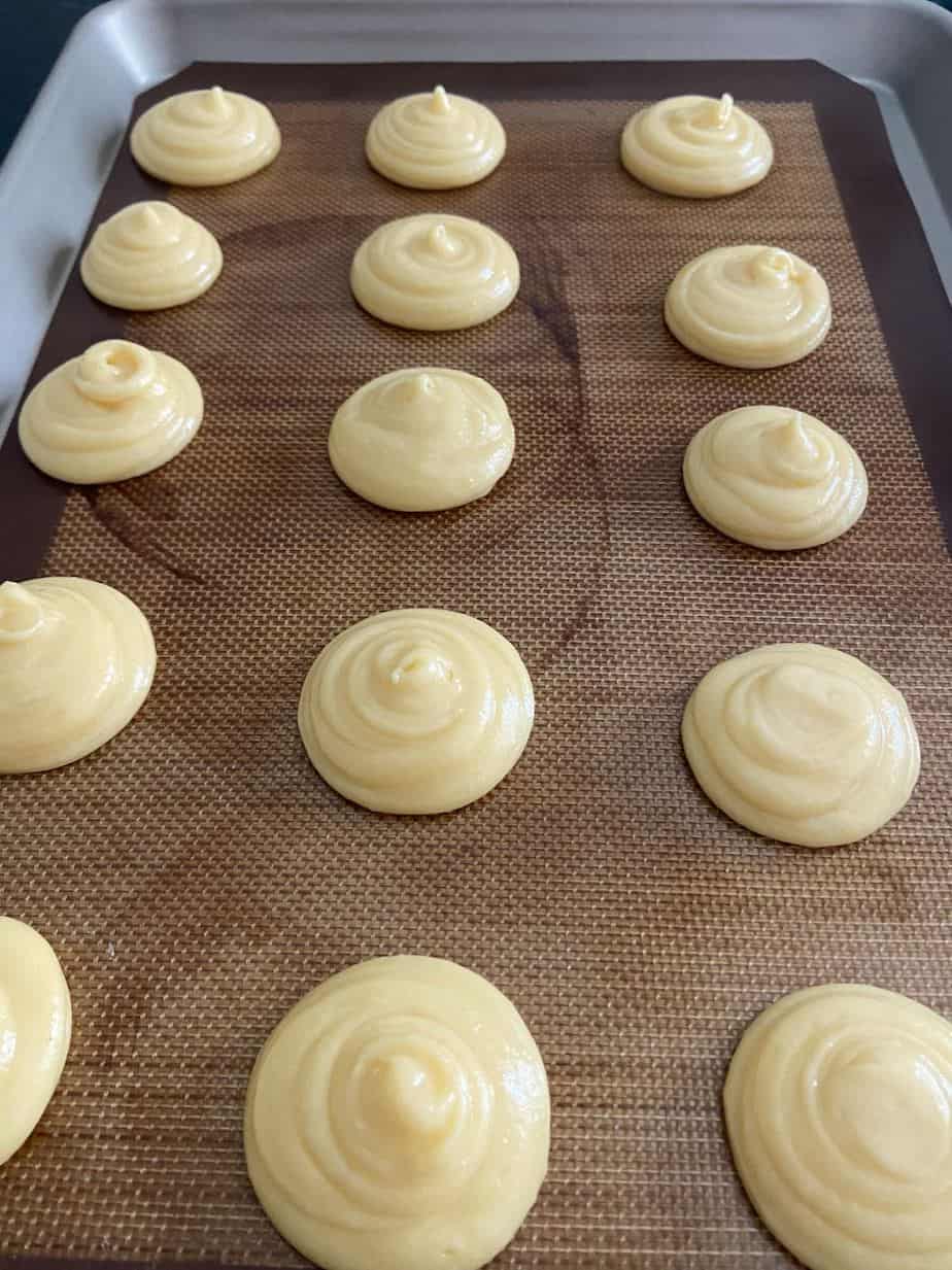 Cream puff choux pastry on baking sheet.