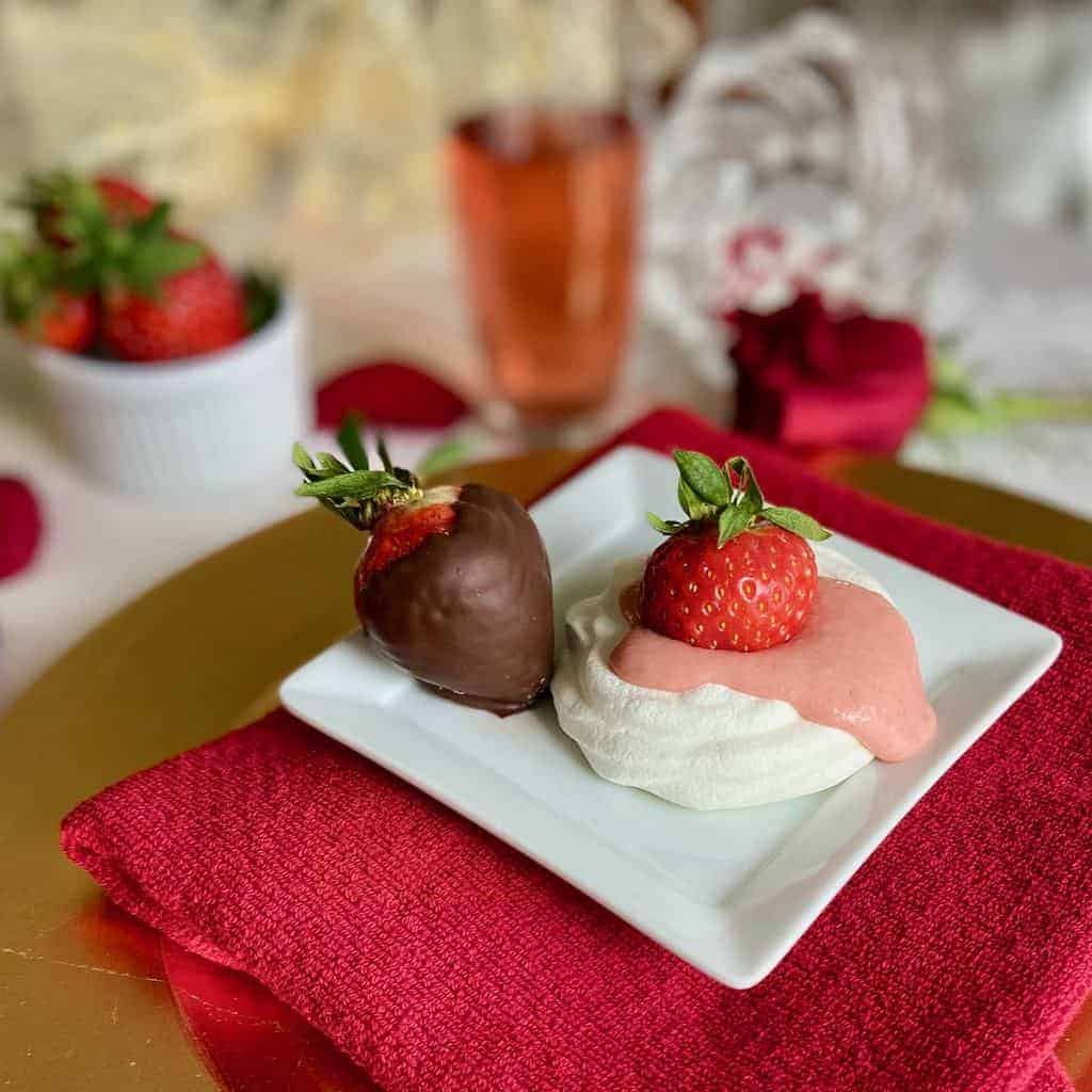 Mini Pavlova with Strawberry Curd and chocolate covered strawberries on plate.