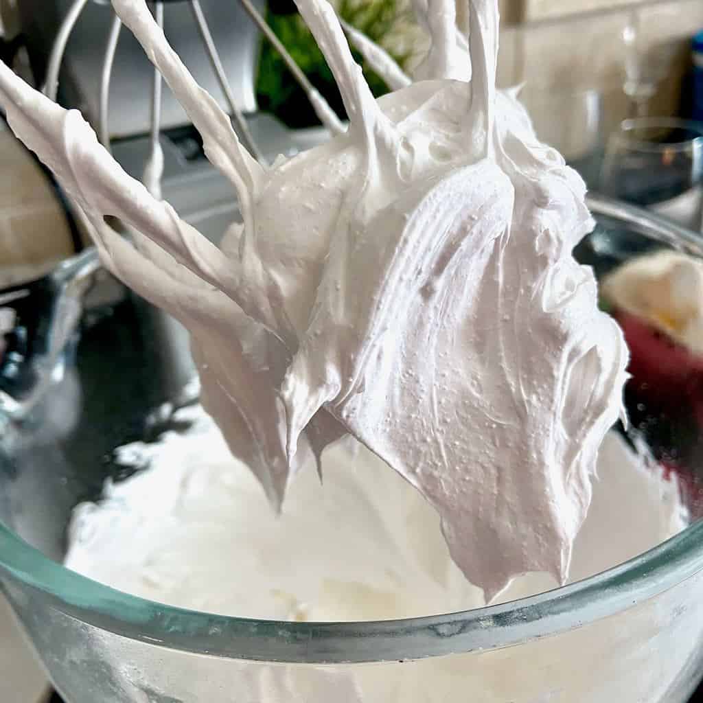 Stiff peaks of egg whites on whisk attachment.