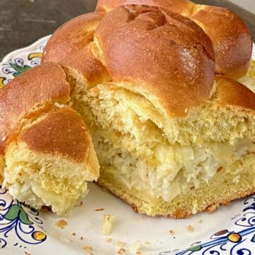 Challah bread loaf stuffed with roasted cauliflower spread and sliced.
