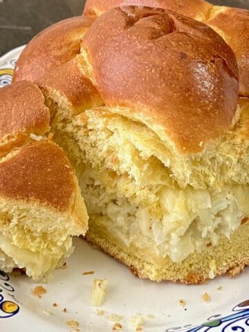 Challah bread loaf stuffed with roasted cauliflower spread and sliced.