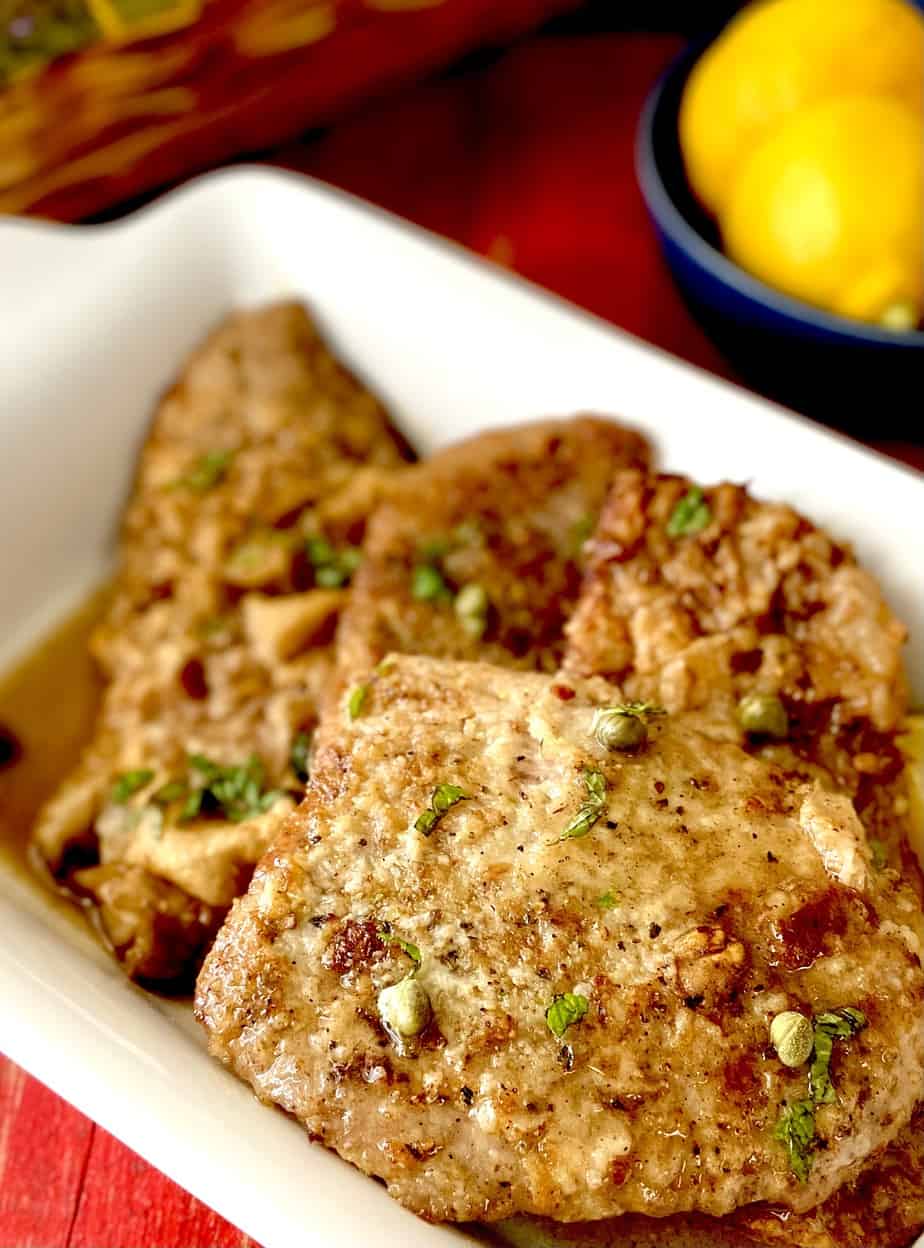 Veal scallopini on a white platter.