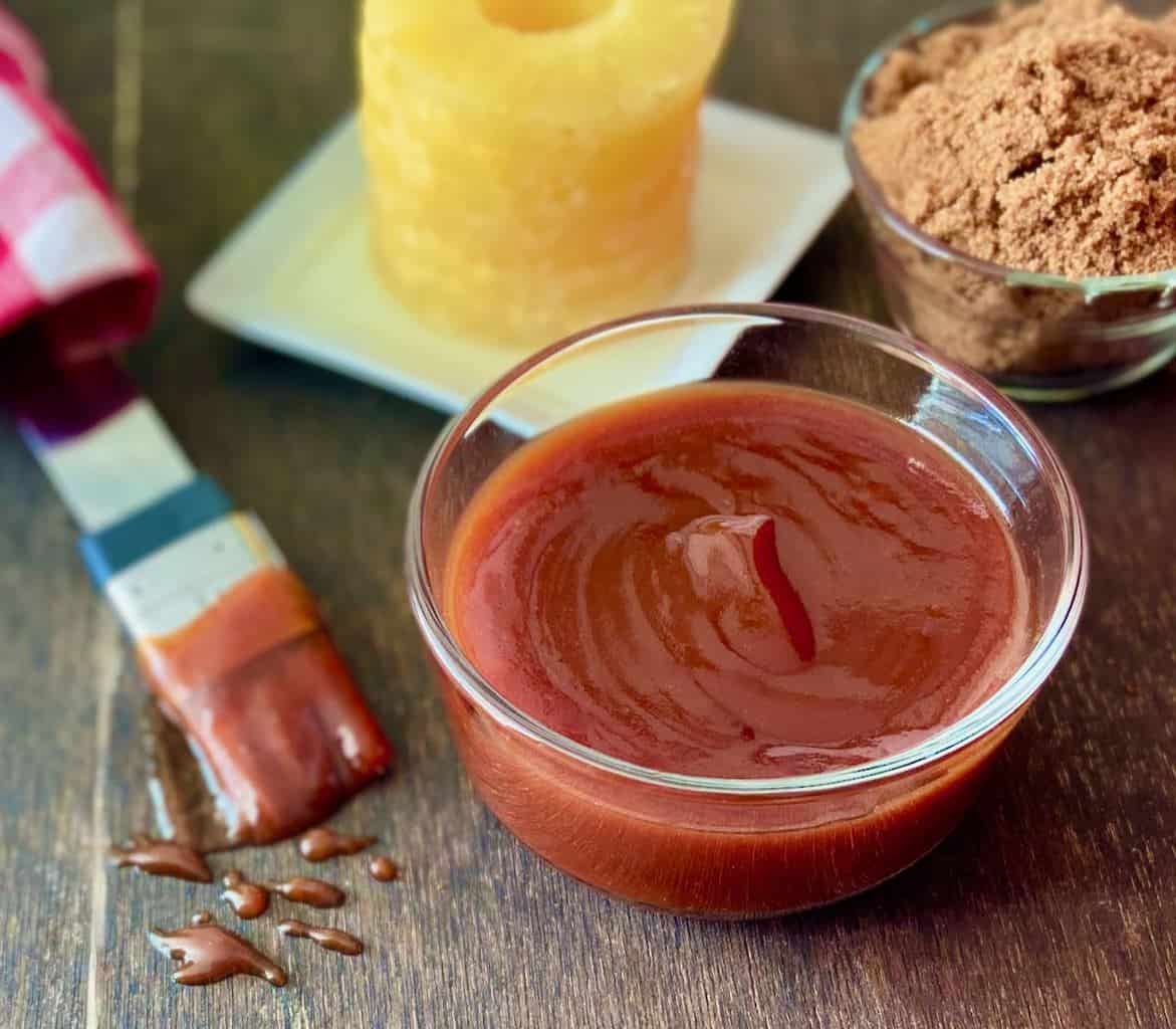 Sauce in glass bowl on brown table.