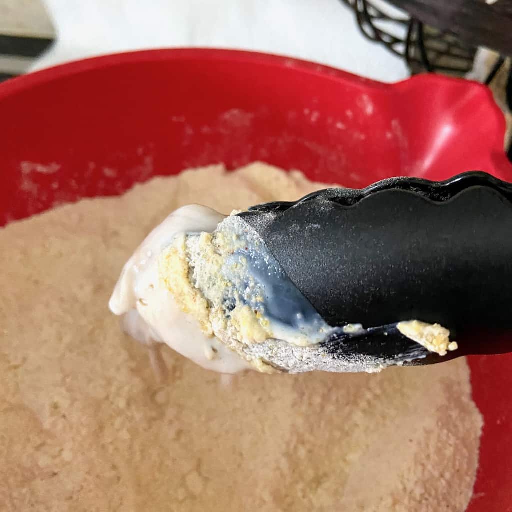 Oyster being dredged in cornmeal mixture.