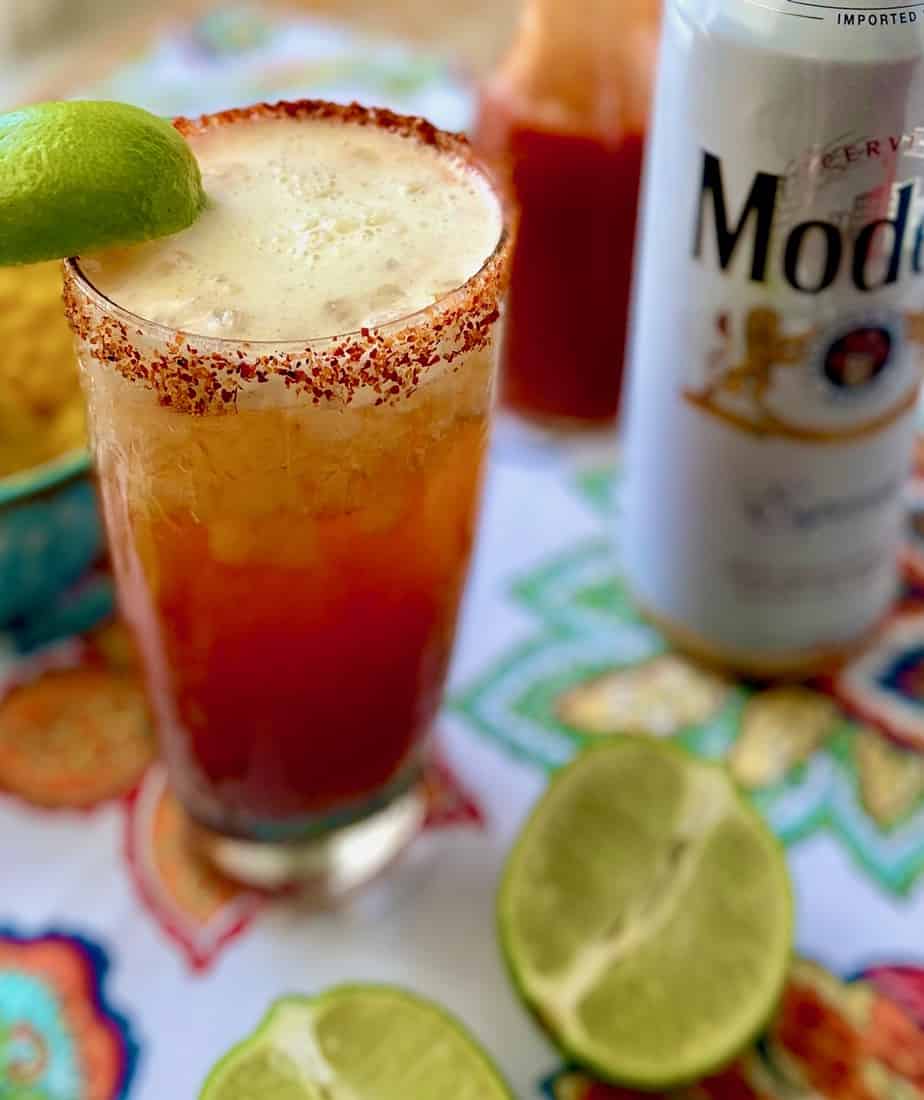 Michelada mexican cocktail in frosty glass with slice of lime.