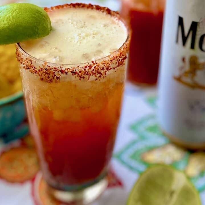 Close up of Michelada garnished with lime wedge.