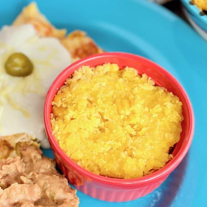 Sweet Corn Tomatilo in red ramekin on blue plate.