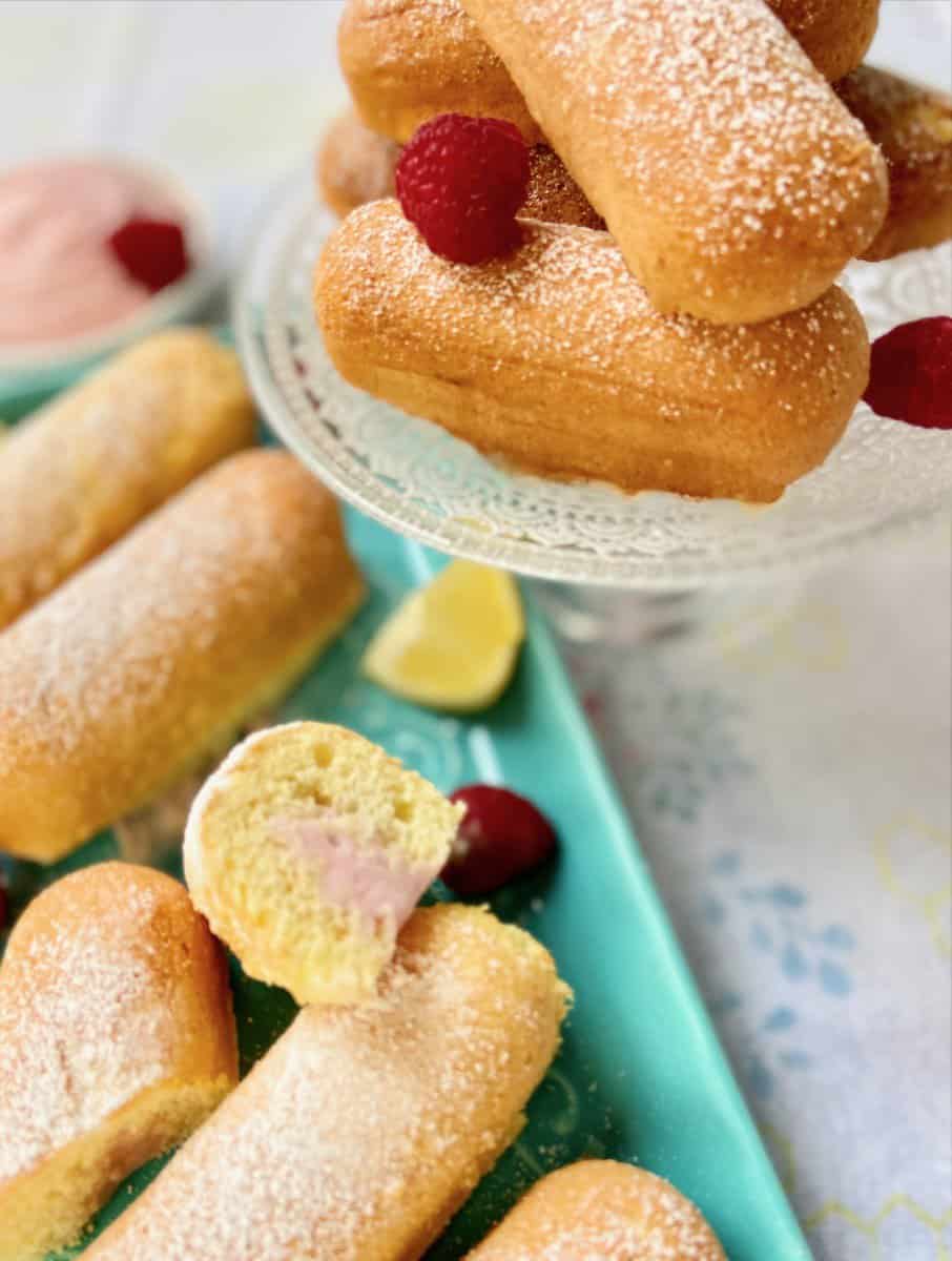 Twinkies on a serving tray garnished with lemon slices and raspberries.