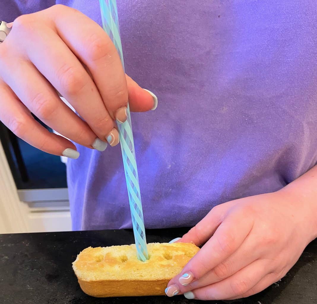 Model demonstrating how to poke holes in the bottom of the twinkie.