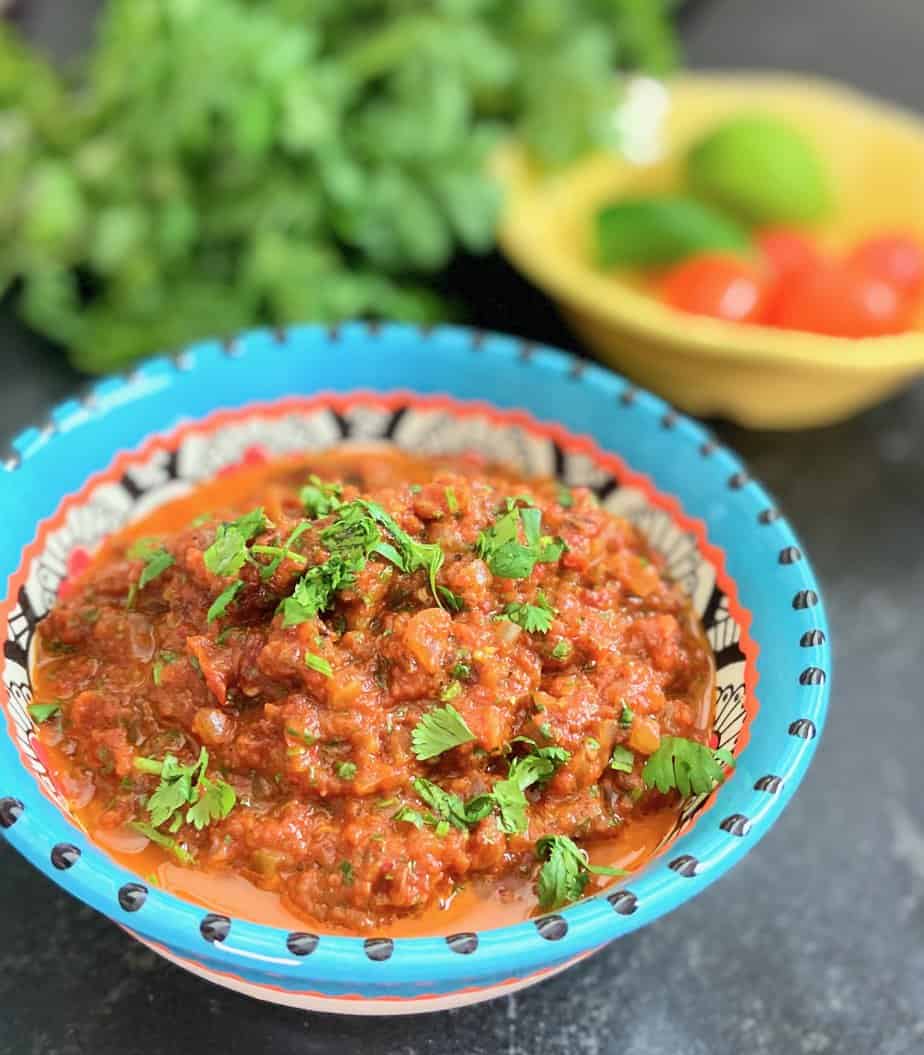 Ranchero sauce in decorative bowl garnished with chopped cilantro.