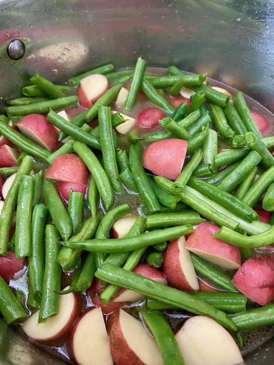 Beans and potatoes in cooking pot.