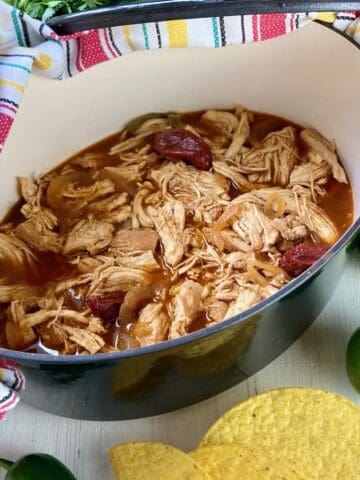 Dutch Oven Chicken Carnitas in black pot.