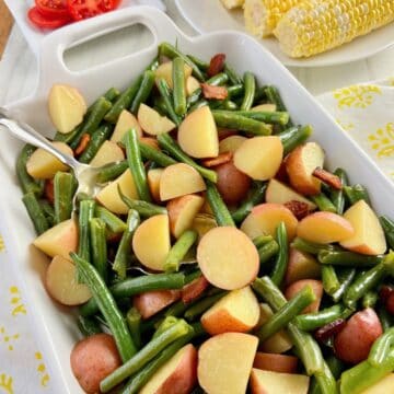 Green beans and potatoes in white serving dish.