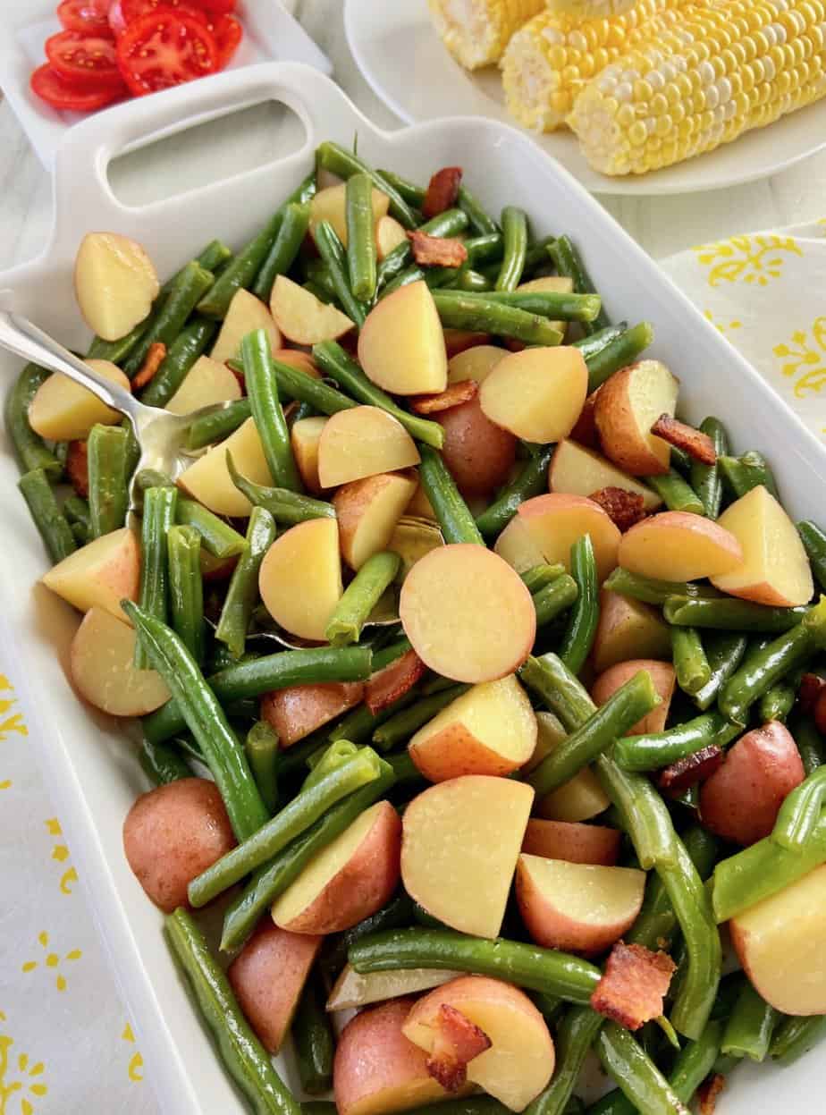 Beans and potatoes on white serving platter.