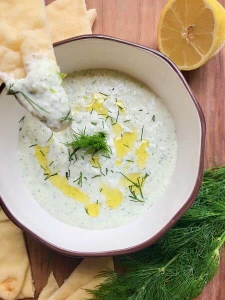 Greek yogurt dip in bowl with naan bread.