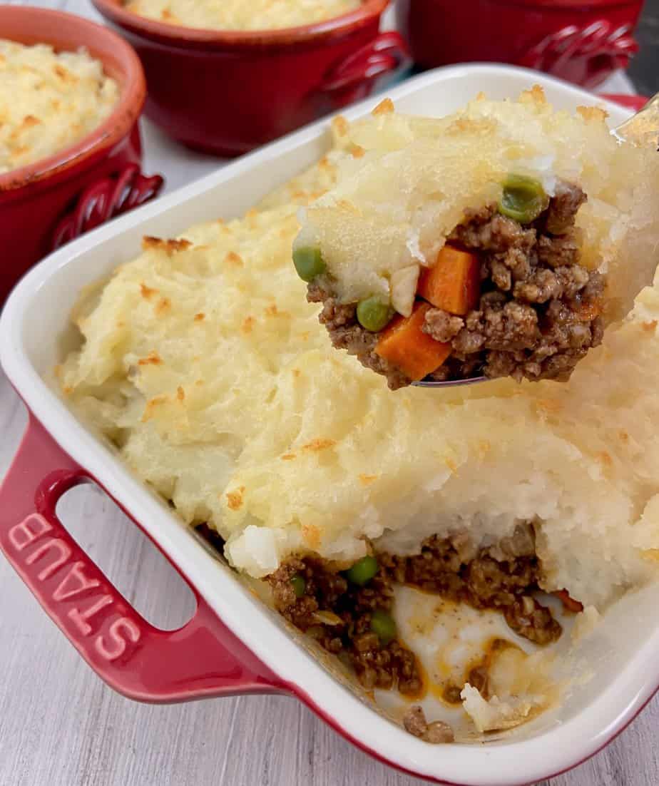 Spoonful of cottage pie hovering over casserole.