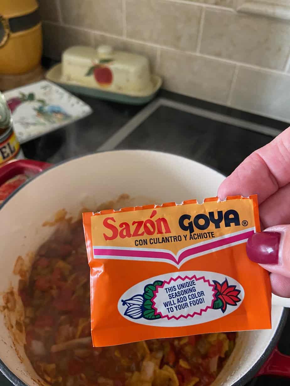 Packet of Mexican seasoning being added to stockpot.