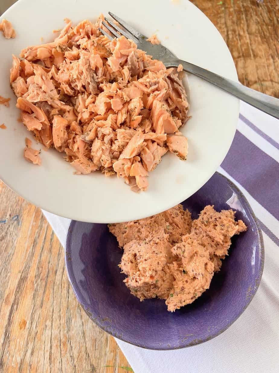 Shredded salmon being added to food processor.