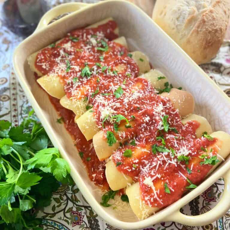 Manicotti crepes in baking dish.