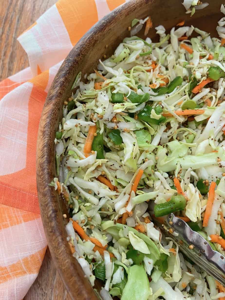 Chopped vinegar coleslaw in wooden bowl.