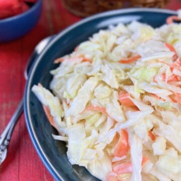 Shredded coleslaw in black bowl.