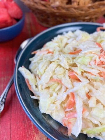 Shredded coleslaw in black bowl.