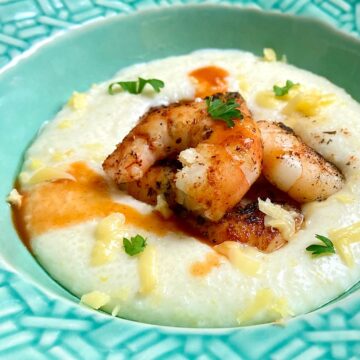 Blackened shrimp and grits in turquoise bowl.