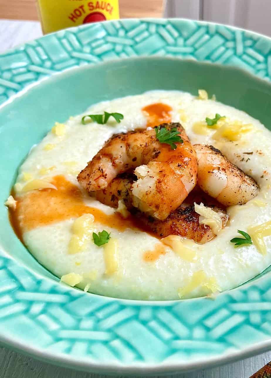 Blackened shrimp and grits in turquoise bowl.