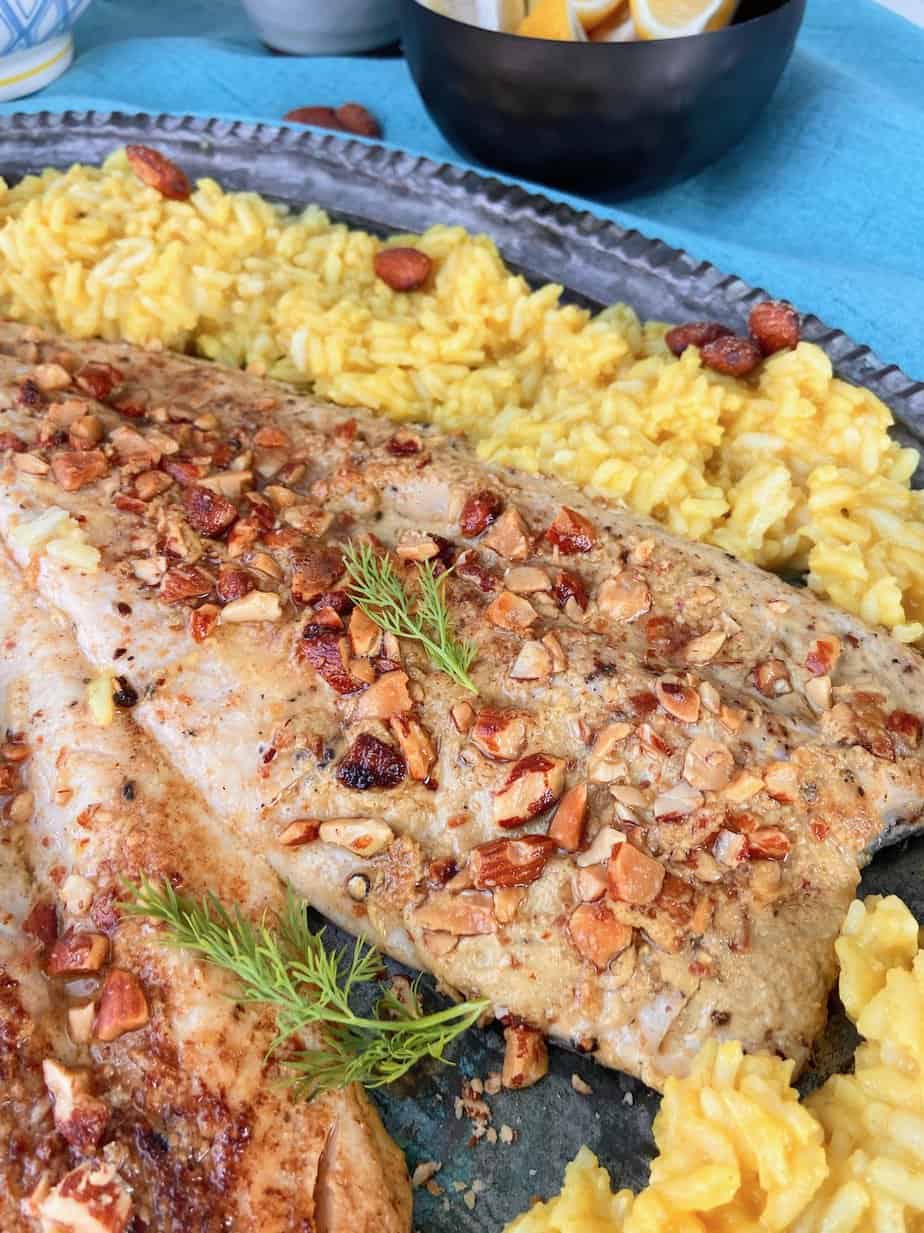 Pan fried trout with toasted smokehouse almonds on serving platter.