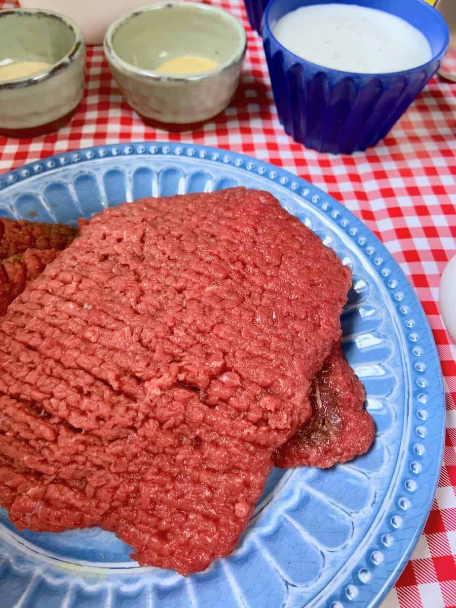 Tenderized cube steak for Dairy Queen steak fingers recipe on a blue plate.