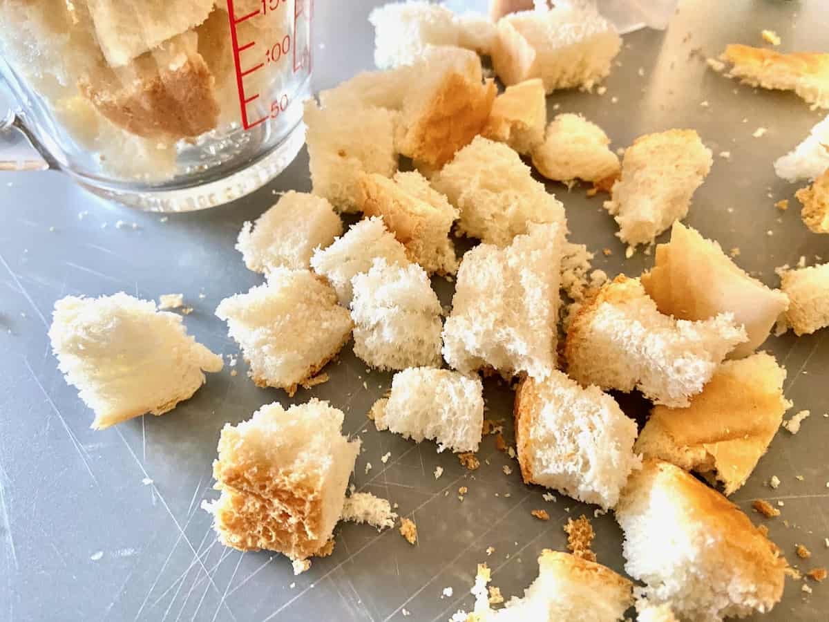 Bread cubes on cutting board.