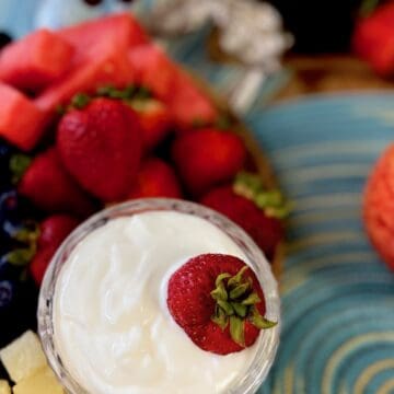 White fruit dip with red strawberry in it.