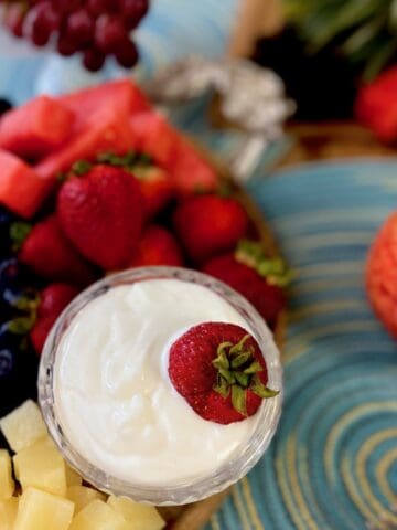 White fruit dip with red strawberry in it.