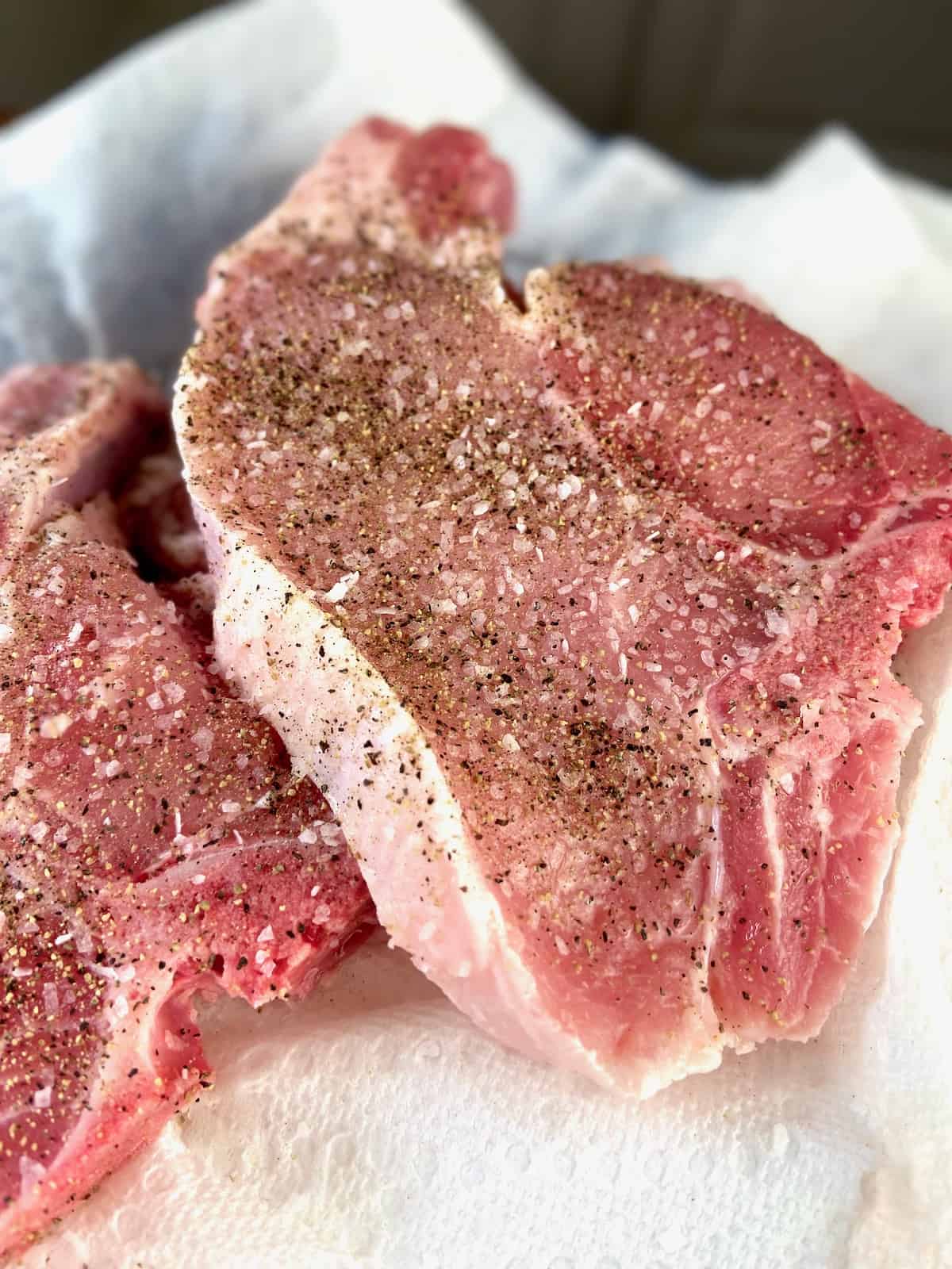 Pork chops seasoned with salt and pepper.