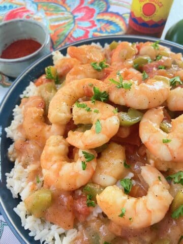 Shrimp etouffee in a blue bowl over white rice.