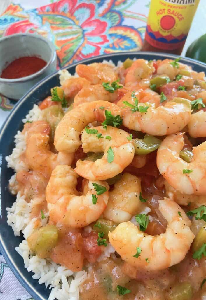 Shrimp etouffee in a blue bowl over white rice.