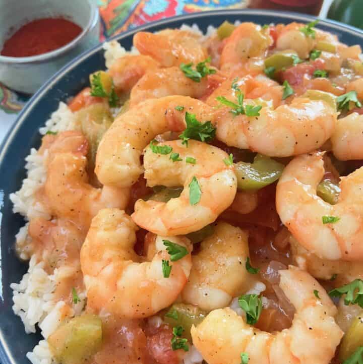 Shrimp etouffee in a blue bowl over white rice.