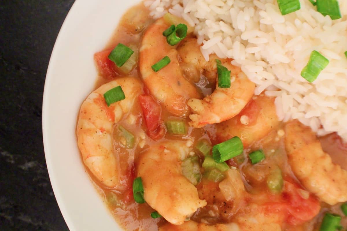 Shrimp etouffee and rice in white bowl.