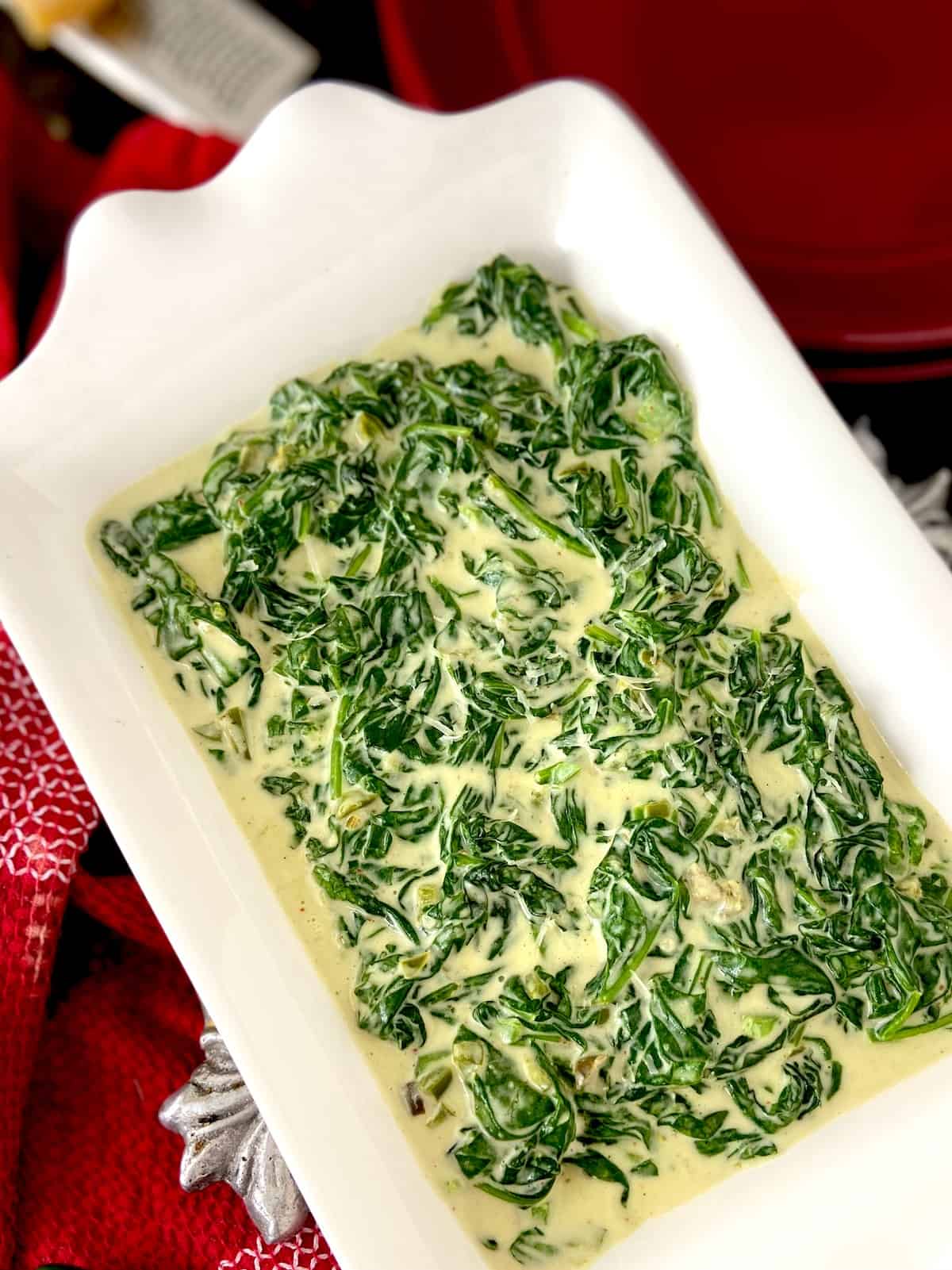 Creamed spinach in white serving bowl.