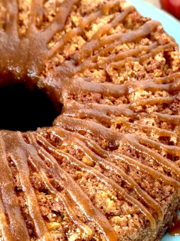 Apple cake with glaze on blue plate.