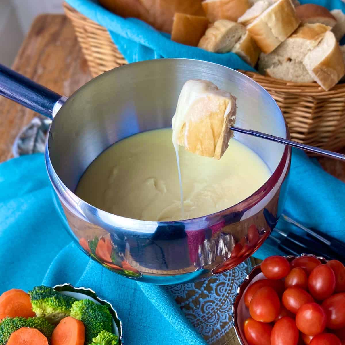 A cube of bread on a skewer dripping with cheese fondue.