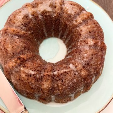 Glazed gingerbread bundt cake on turquoise plate.