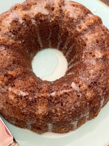 Glazed gingerbread bundt cake on turquoise plate.