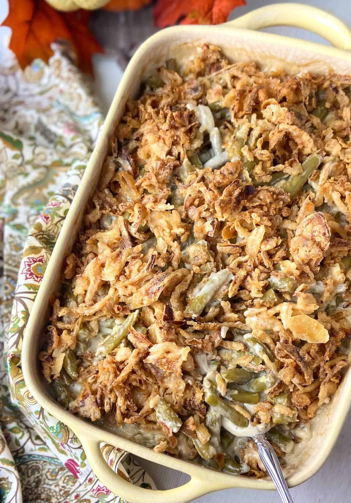 Green bean casserole topped with french fried onions in baking dish.