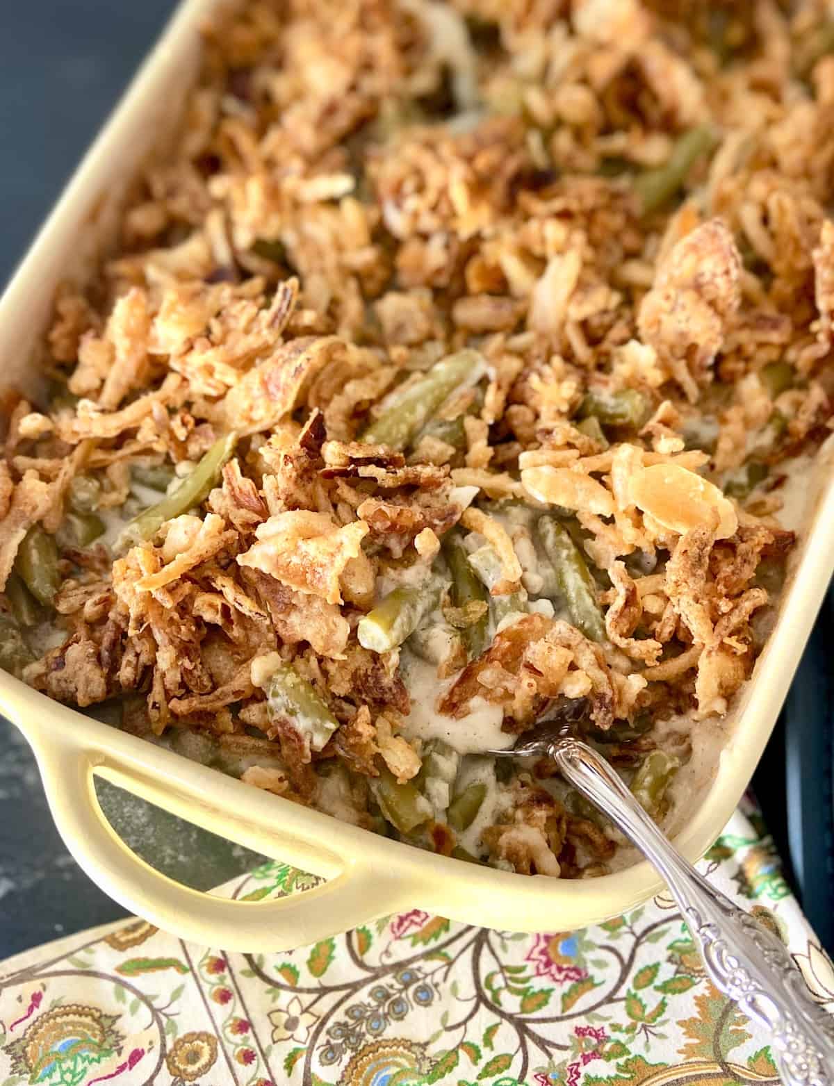 Green bean casserole in pale yellow baking dish.