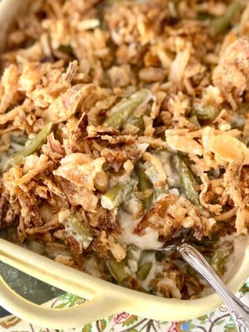 Green bean casserole in baking dish with serving spoon.