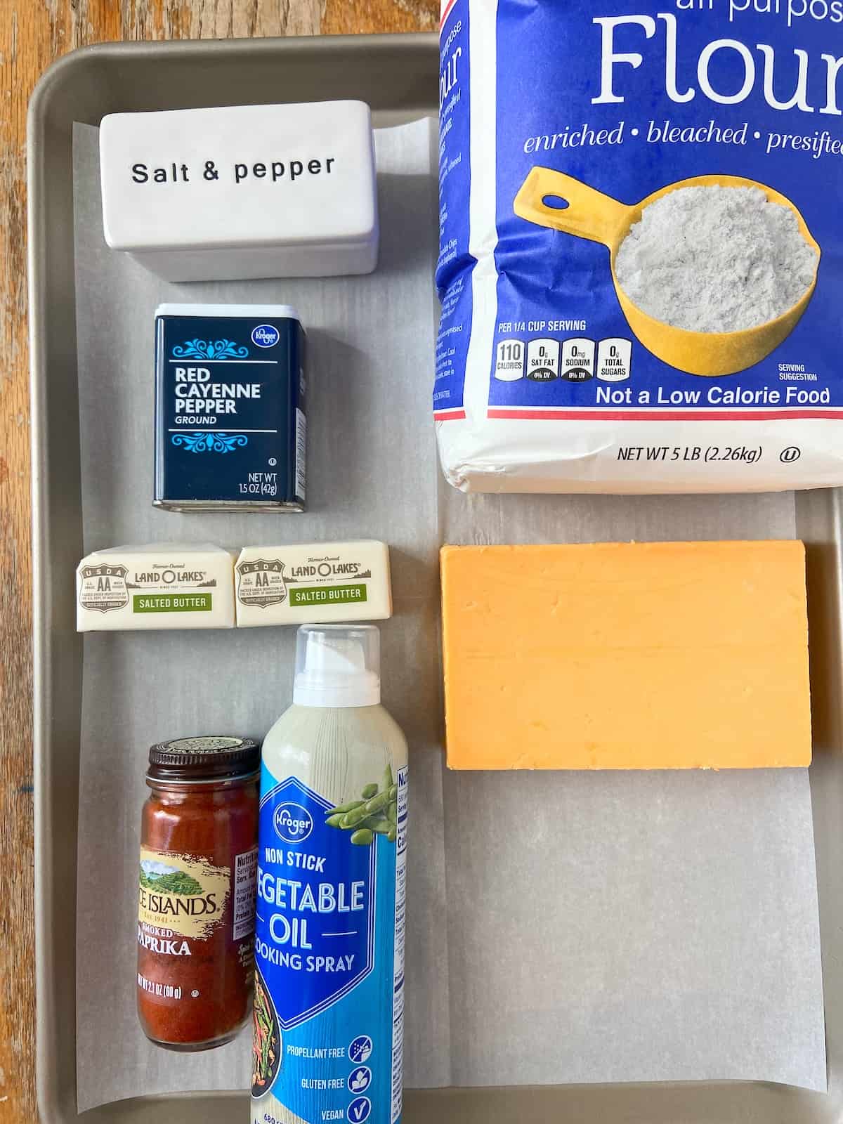 Ingredients for cheddar cheese wafers on baking sheet with parchment paper.